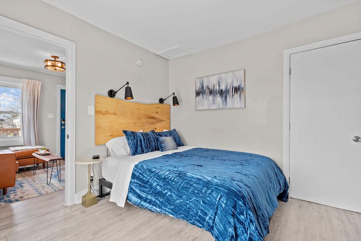 Chumba cha kulala cha kifahari chenye kitanda aina ya queen chenye mashuka laini, mwanga wa joto na ubao wa mbao wa kisasa kwa ajili ya sehemu ya kukaa ya kupumzika ya Midtown