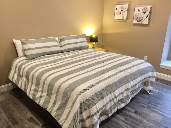 Grande suite King Size avec salle de bain principale complète, TV HD, commode et placard.