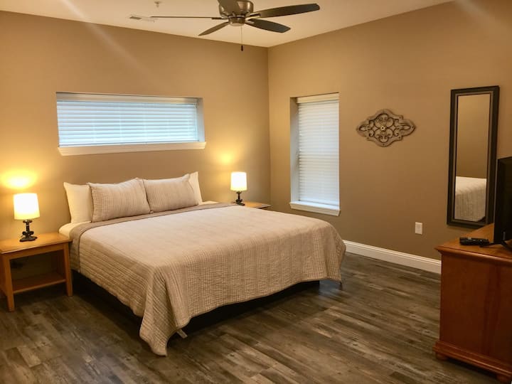 Grande suite King Size avec salle de bain principale complète, TV HD, commode et placard.