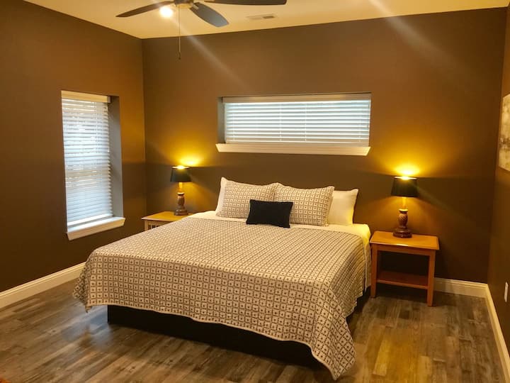 Grande suite King Size avec salle de bain principale complète, TV HD, commode et placard.