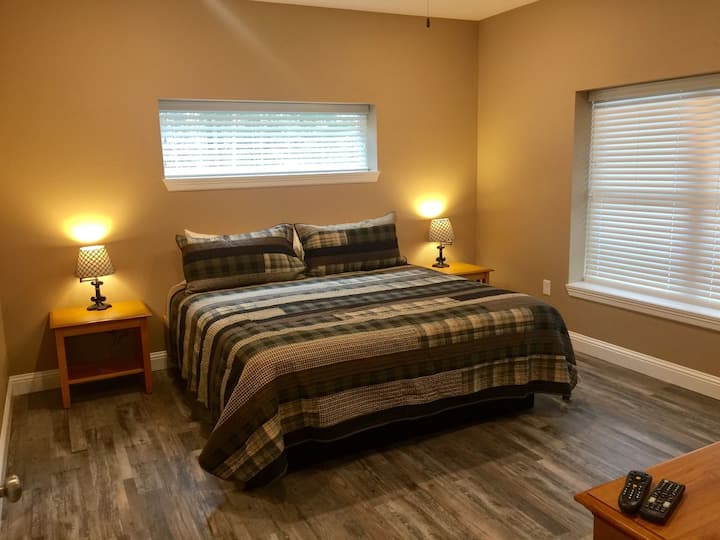 Grande suite King Size avec salle de bain principale complète, TV HD, commode et placard.