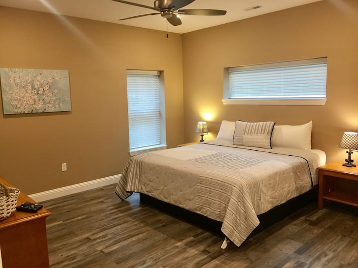 Grande suite King Size avec salle de bain principale complète, TV HD, commode et placard.