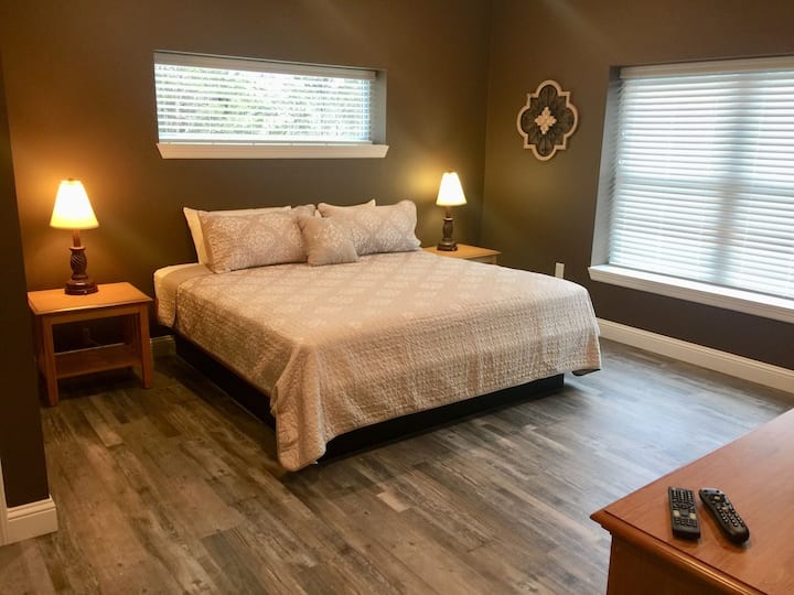 Grande suite King Size avec salle de bain principale complète, TV HD, commode et placard.