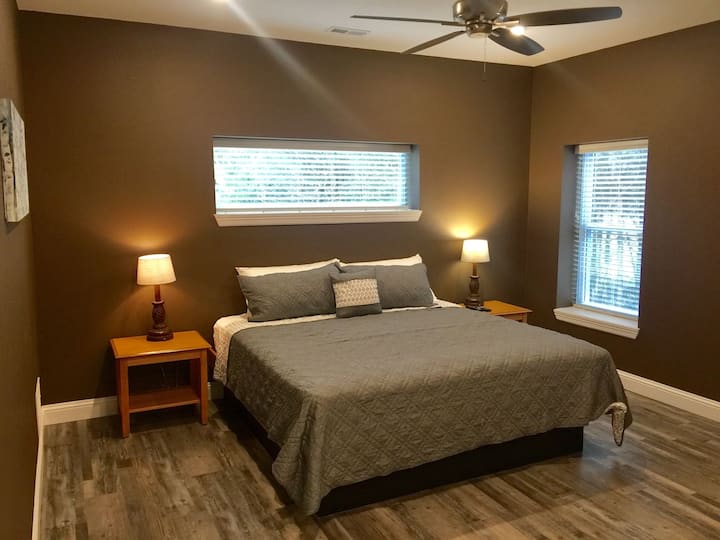 Grande suite King Size avec salle de bain principale complète, TV HD, commode et placard.