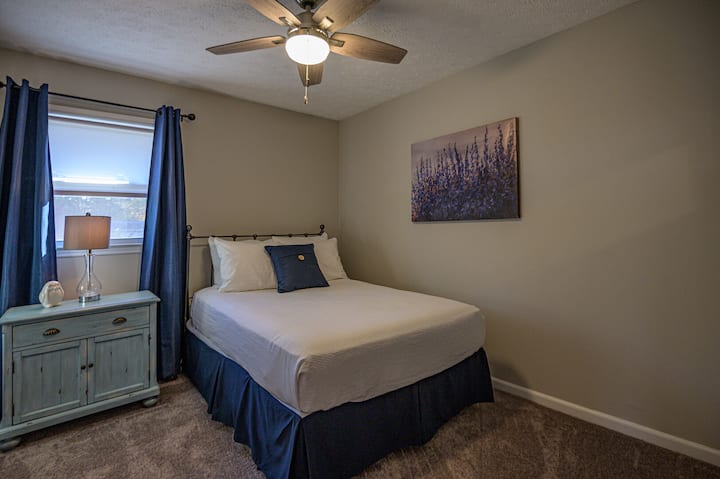 ห้องนอนแขกพร้อมเตียงควีนไซส์และพัดลมเพดาน