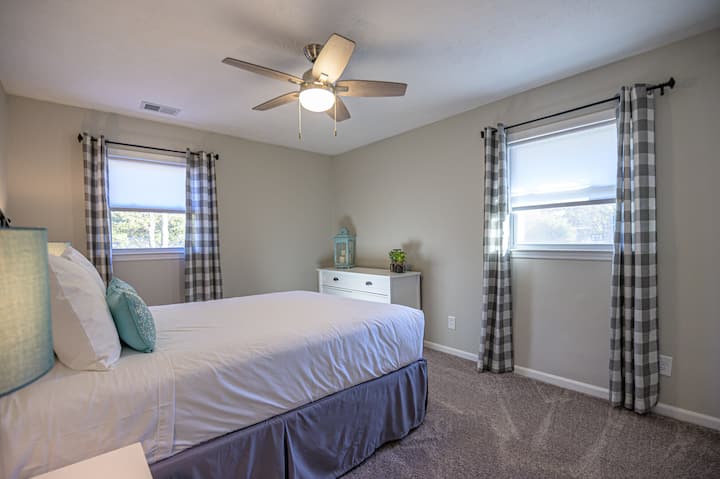 ห้องนอนผู้เข้าพักมีเตียงควีนไซส์และพัดลมเพดาน