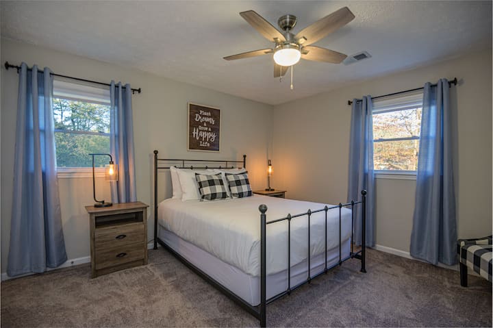 ห้องนอนผู้เข้าพักมีเตียงควีนไซส์และพัดลมเพดาน