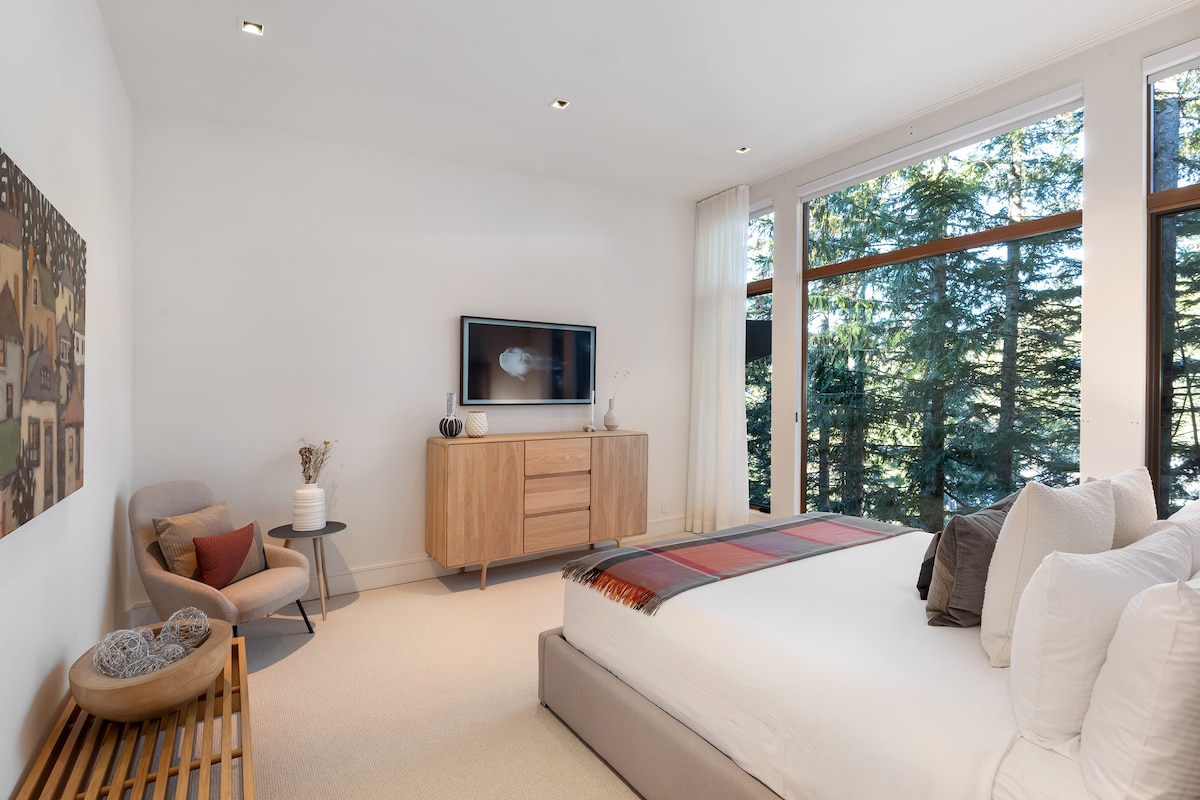 - Bedroom 2 – King room with expansive windows framing calm forest views
- Soft tones, cozy bedding, and modern seating create a soothing retreat
- A bright peaceful space designed for restful nights and relaxing stays
