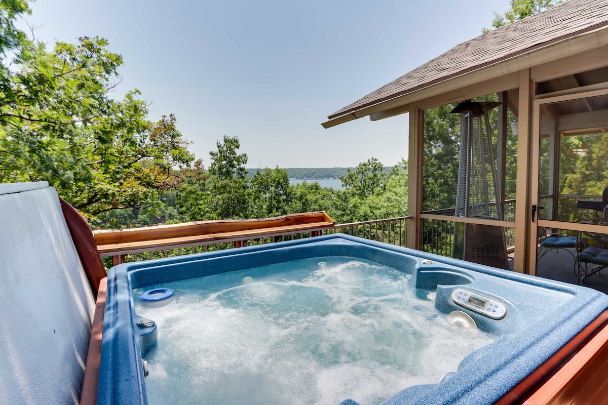 A private hot tub is positioned on a deck overlooking the lake, offering scenic views of the surrounding trees and water. The relaxation area includes a propane patio heater nearby, enhancing the outdoor experience.