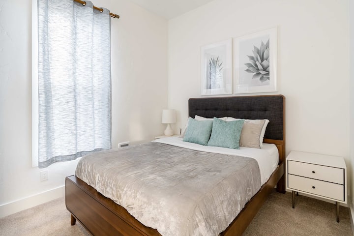 Bedroom 2 with queen bed and side table.