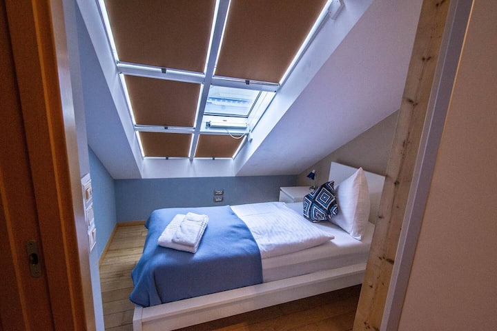 第三间卧室配有舒适的单人床、床头柜和大衣柜。这个房间有空调