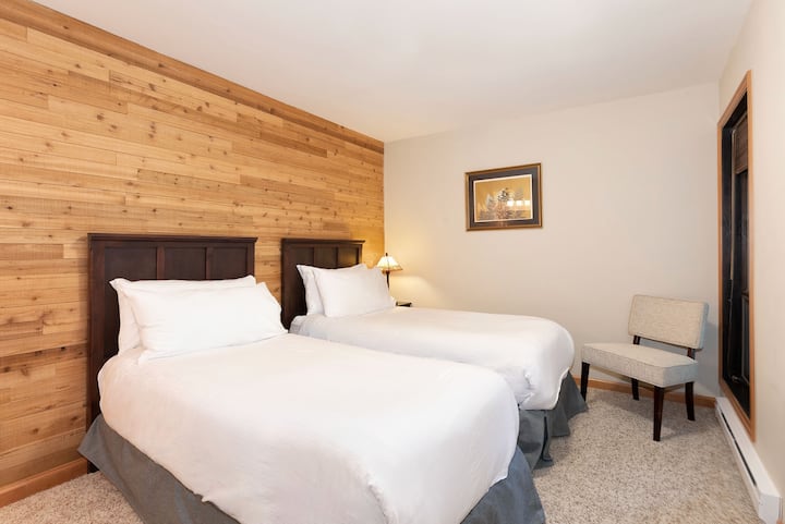 – 3. spavaća soba – svijetla soba s dva kreveta, prirodnim drvenim teksturama i nježnim neutralnim dekorom  
– veliki prozor kroz koji se pruža pogled na šumu  
– Udoban smještaj za obitelji i grupe  
