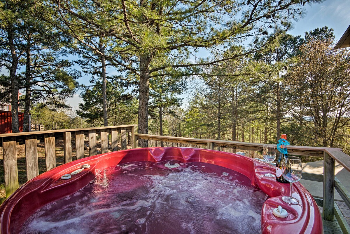 A red hot tub is situated on a wooden deck, surrounded by tall trees and natural woodland. The inviting water surface reflects sunlight, creating a serene atmosphere for relaxation amidst nature.