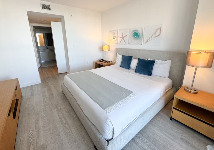 غرفة نوم واسعة مع سرير كبير والكثير من الضوء الطبيعي.