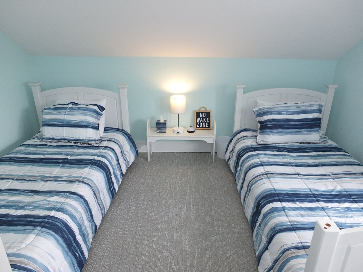 Sala de estar en la planta superior: podría considerarse un tercer dormitorio, pero no tiene entrada privada.  Se encuentra en la parte superior de las escaleras hasta el segundo piso.  Tiene 2 camas individuales, una mesita de noche y un armario.