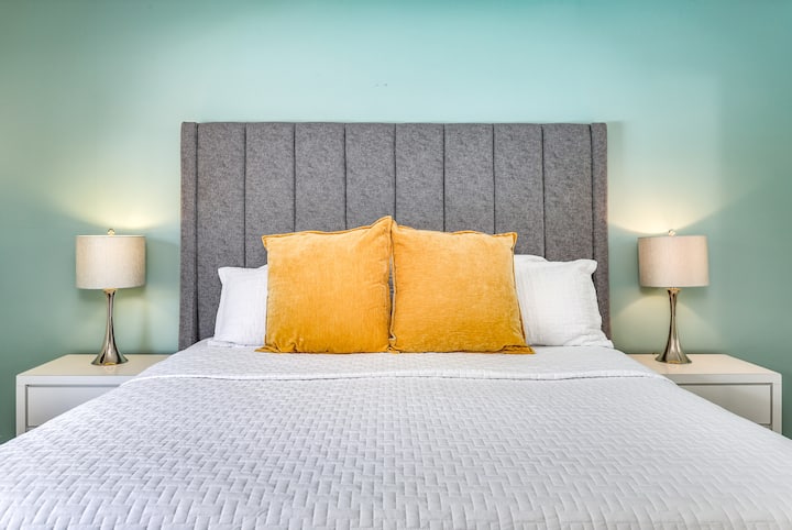 Primer plano de una lujosa cama tamaño king con iluminación de diseño