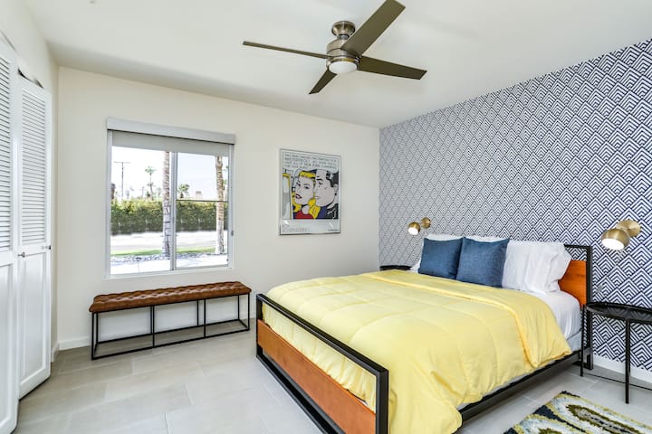 Vista detallada del dormitorio con papel tapiz tropical e iluminación suave