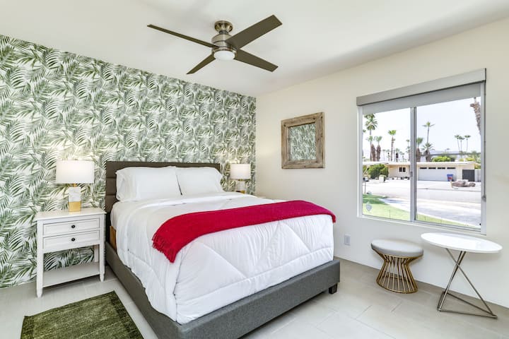 Dormitorio luminoso con vistas a las palmeras y asientos acogedores