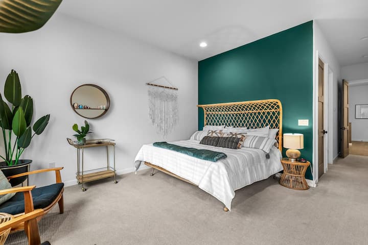 Large master bedroom with comfy beds on Anthropologie Rattan Bed frame.