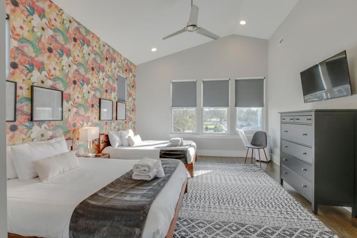 Bedroom with floral wallpaper and TV.