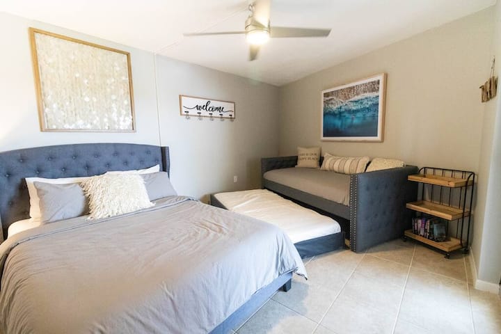 Სტუმრების საძინებელში კედელზე მიმაგრებულია ბრტყელეკრანიანი ტელევიზორი კაბელით