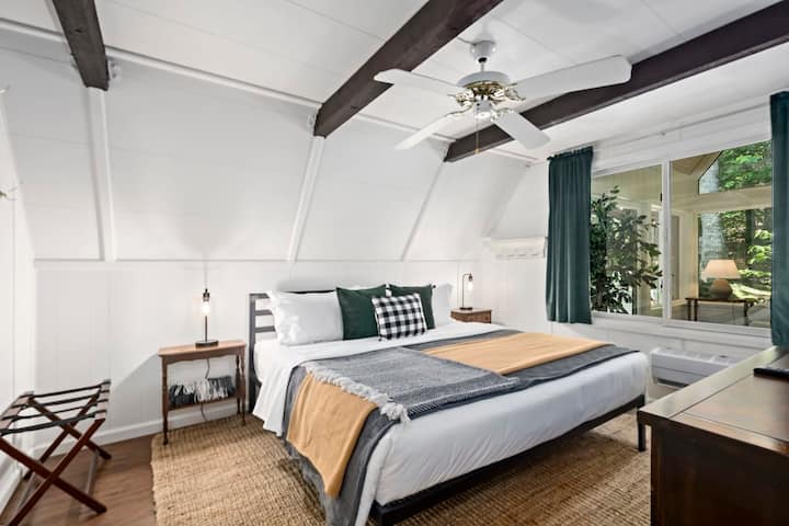 ჰაეროვანი საძინებელი თაღოვანი ჭერითა და რბილი ბუნებრივი სინათლით.