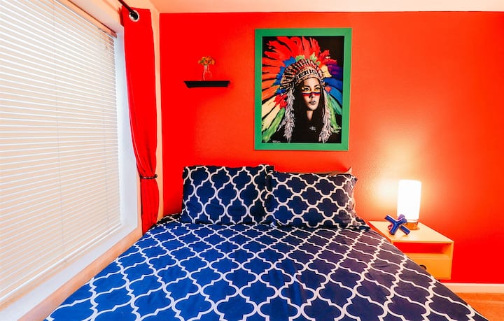 Ჩაუღრმავდით ფერებისა და კულტურის სიმფონიას. Ნარინჯისფერი კედლები და ლურჯი ლეიბი ქმნის მშვიდ ტილოს, ხოლო ინდოელი ქალის მომხიბლავი ნახატი მუდმივ ელეგანტურობას ანიჭებს.  #ColorfulEscape #CulturalElegance