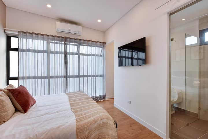 Large bedroom with A/C, smartTV and access to private bathroom. Window has curtains and blackouts as well.