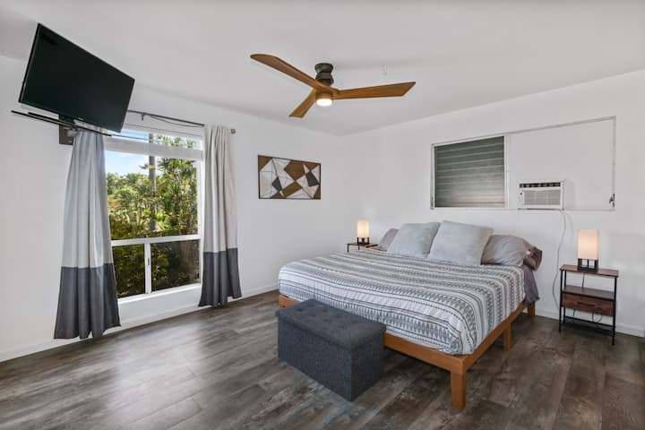 חדר שינה ראשי עם מיזוג אוויר, מיטת קינג סייז, טלוויזיה ווילונות האפלה.