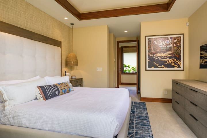 Vista privilegiada del dormitorio de invitados dos con cama tamaño king, TV de pantalla plana montada en la pared y techos validados.