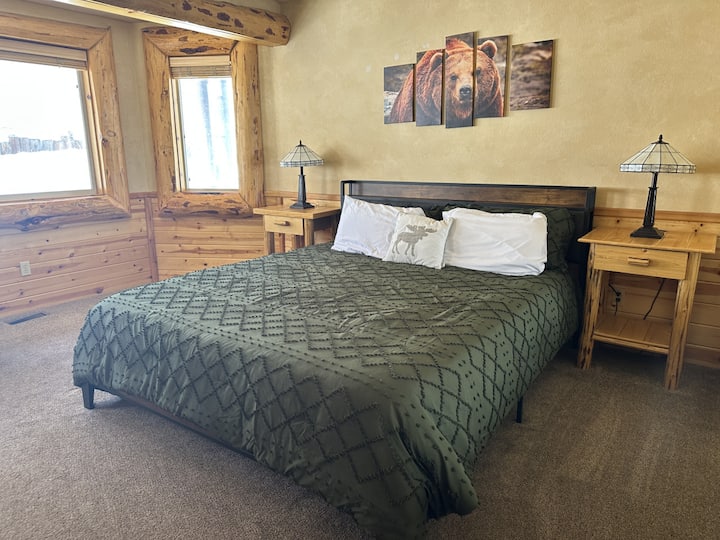 Foto del dormitorio principal con lámparas a juego, muchas ventanas y vestidor con televisor inteligente de 40 pulgadas y baño privado.