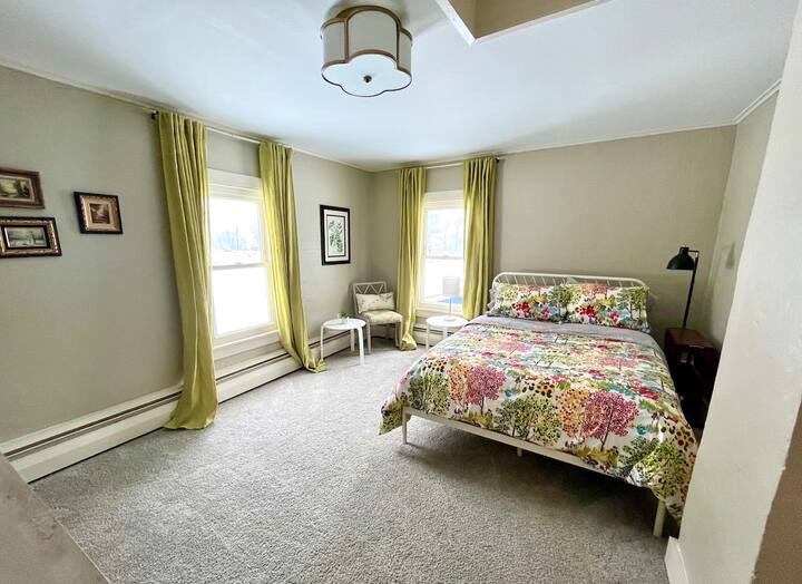 Hosťovská spálňa s manželskou posteľou, šatníkom a komodou.