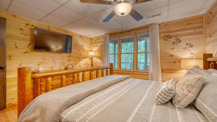 Საძინებლის ქვედა ნაწილი დიდი საწოლით, ჭკვიანი ტელევიზორით და სანაპიროს ხედით