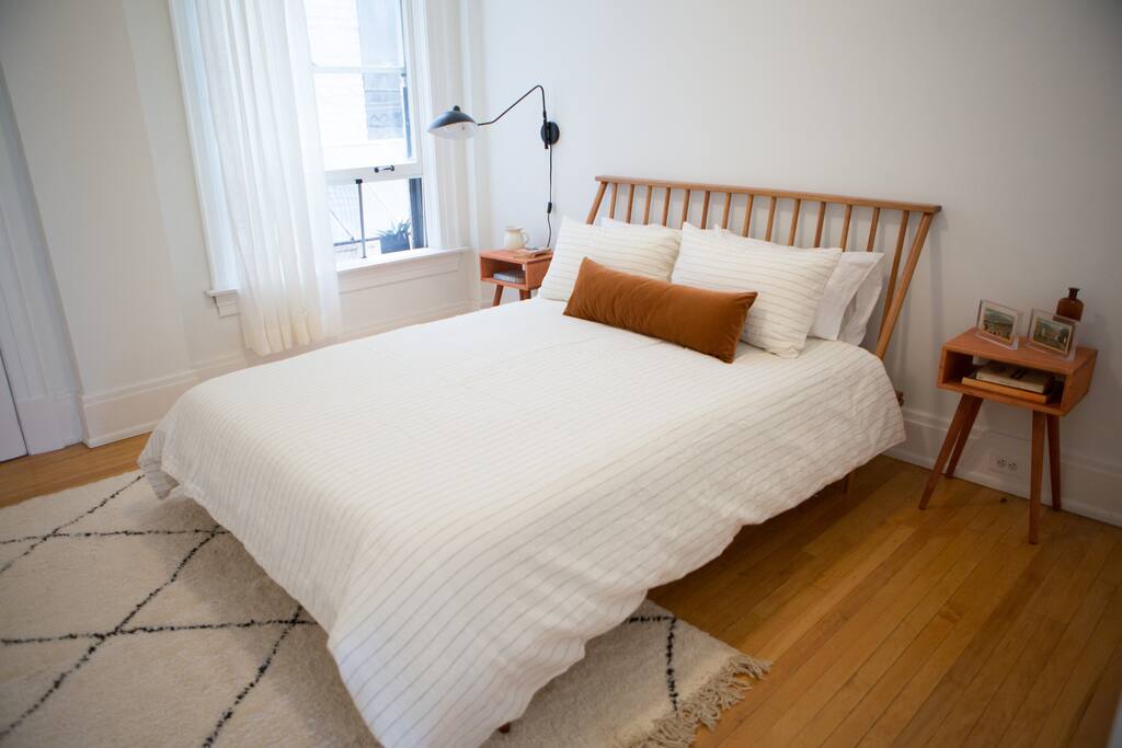 Master bedroom with large window, Moroccan rug, and comfy mattress