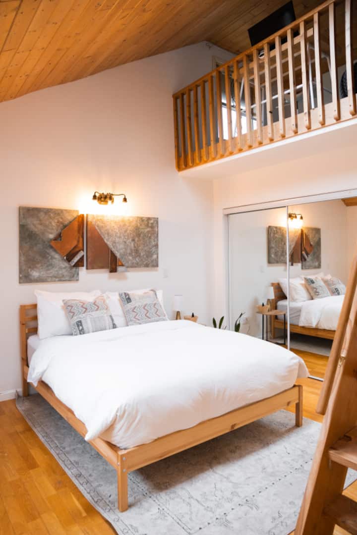 Master bedroom with queen bed and a loft workspace/chill zone. This bedroom has direct access to the bathroom.