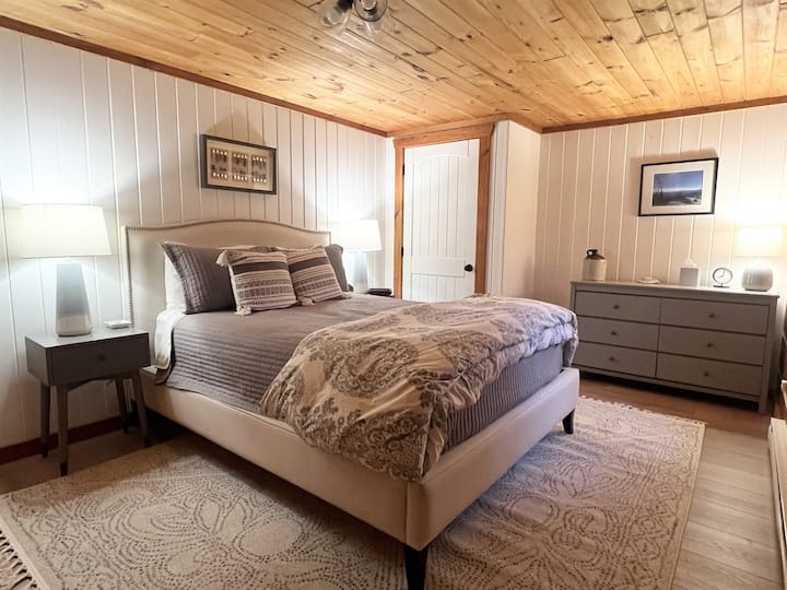 Lower-level Bedroom #1 features a queen bed, convenient storage, side chair, and blackout-shaded window - perfect for a restful night after a day in the mountains. 