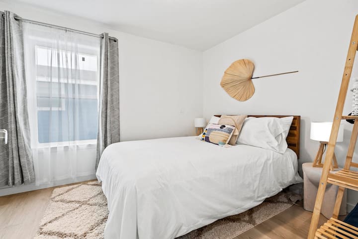 Dormitorio queen luminoso y sereno con texturas acogedoras y toques costeros relajantes.
