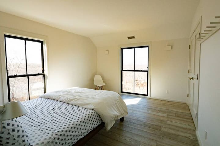 The second bedroom has a queen size bed and west-facing and north-facing floor to ceiling windows.