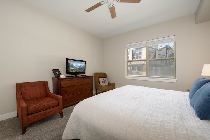 Master suite with king bed, ensuite bathroom, TV, seating and slope views