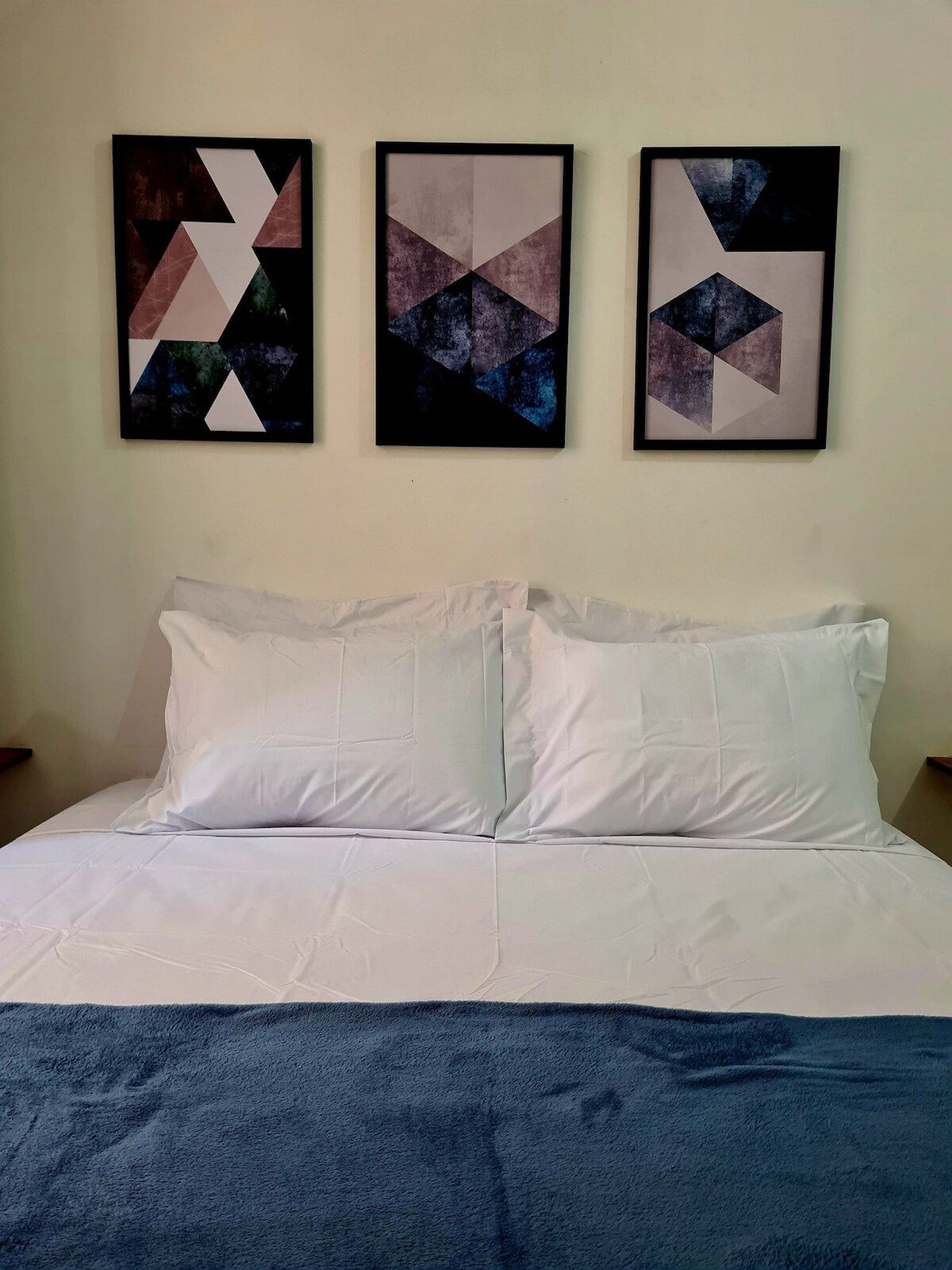 חדר עם מיטת קווין סייז, חלון עם אור טבעי, מיזוג אוויר, קולבים, ארון, אהיל, מראה, מאוורר נייד, מעוצב עם מסגרות על הקיר.