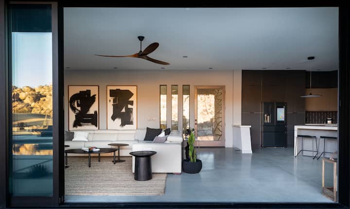 Open the retractable floor-to-ceiling sliding glass doors to instantly transform the living room and dining room into an indoor / outdoor sanctuary overlooking Joshua Tree’s natural beauty