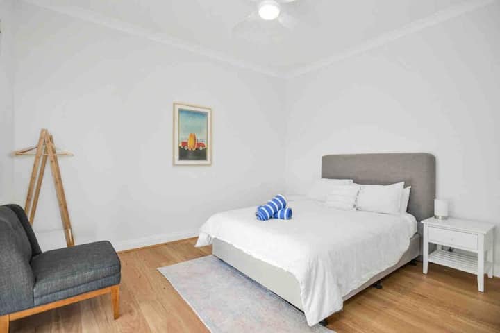 Une chambre simple et accueillante avec un lit queen size, un éclairage doux et des planchers en bois chaleureux.