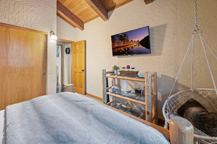 Master bedroom upstairs with queen bed, TV, and en-suite bathroom.