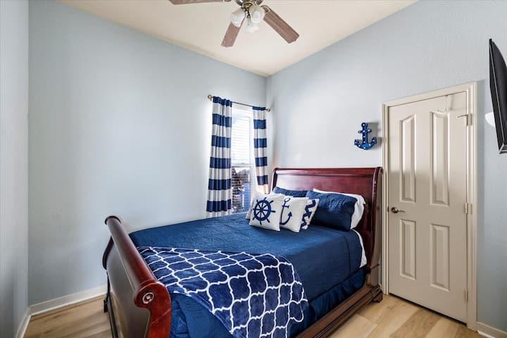 Cozy nautical bedroom with queen sleigh bed, TV & natural light