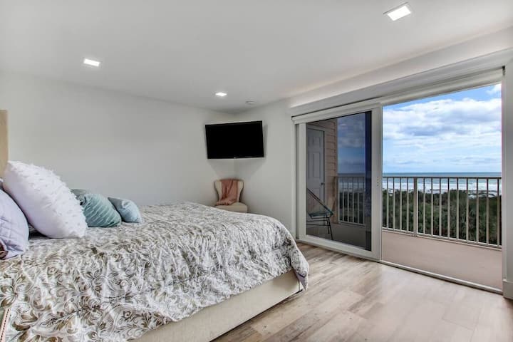 Chambre principale avec lit King Size, télévision et vue : salle de bain attenante.