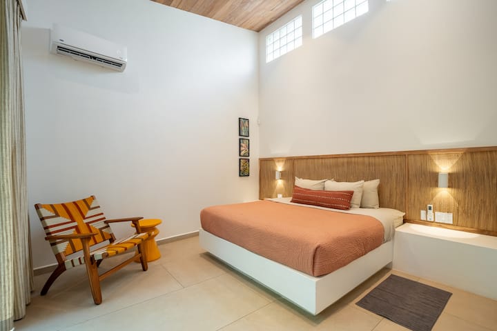Guest King Bedroom: Comfortable King bedroom featuring a private ensuite bath and open closet in a clean, modern space. This bedroom also has a private porch.