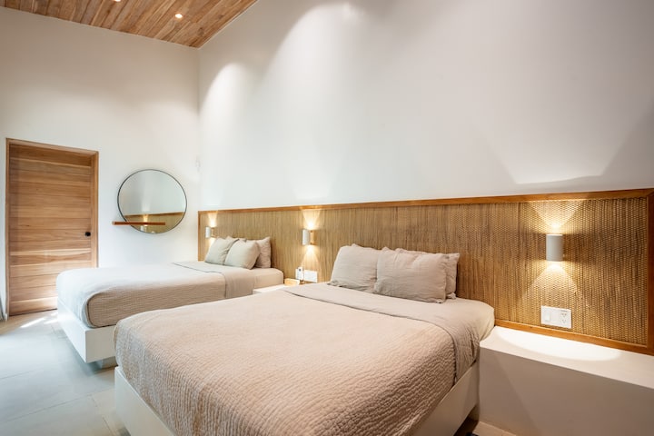 Double Queen Room: Bright room with two Queen beds, ensuite bathroom, and open closet—perfect for families or groups.