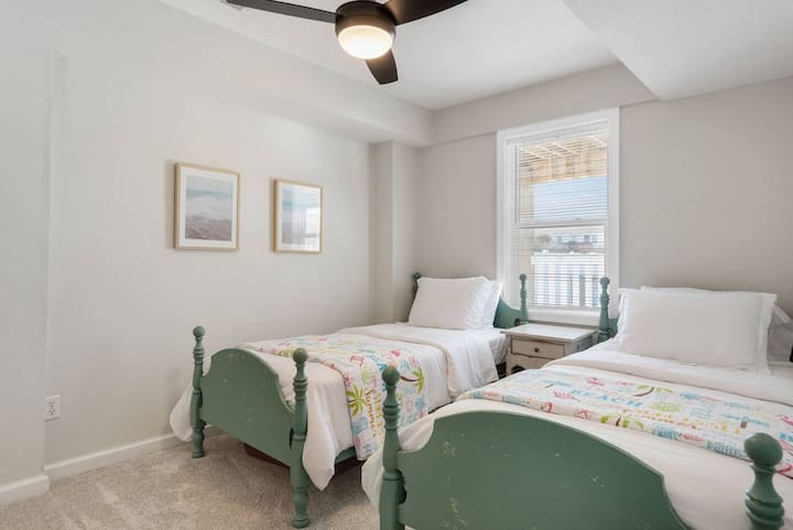 Lower level Twin Bedroom with 2 twin beds, a dresser, and closet with hangers. (1st Level)