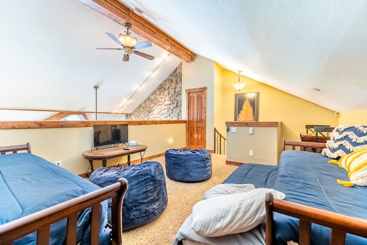 Podkrovie s výhľadom na obývaciu izbu s dvoma samostatnými posteľami a jedným dvojlôžkom.