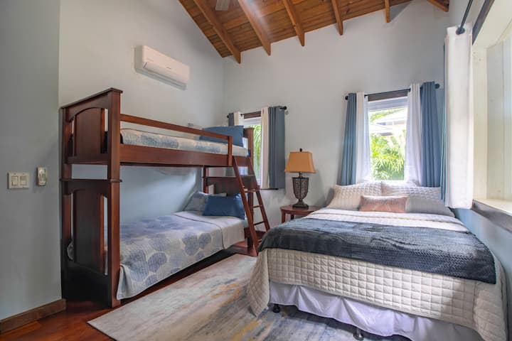 The guest bedroom comfortably sleeps four, featuring a bunk bed and a full-size bed, making it an ideal space for families or groups.